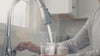 A video showing a women filling a glass of water, taking 2 pills of a supplement, going out for a jog and then coming home